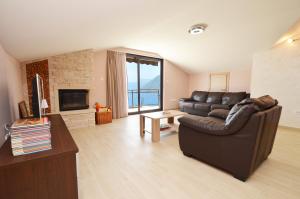 a living room with a leather couch and a television at Apartments Kaludjerovic in Kotor