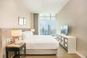 Postel nebo postele na pokoji v ubytování Magnolias Ratchadamri Boulevard Serviced Residences