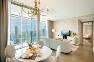 uma sala de estar com um sofá e uma mesa em Magnolias Ratchadamri Boulevard Serviced Residences em Bangkok