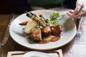 un plato de comida con carne y verduras en una mesa en Bel and The Dragon at Red Lion Wendover, en Wendover