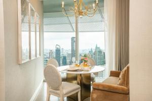 jadalnia ze stołem i krzesłami oraz dużym oknem w obiekcie Magnolias Ratchadamri Boulevard Serviced Residences w mieście Bangkok