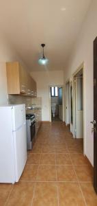 a kitchen with a white refrigerator and a tile floor at Vila Jone in Golem