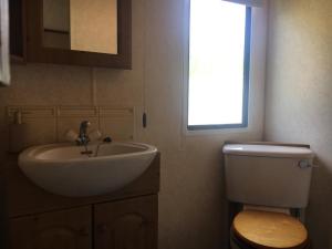 a bathroom with a sink and a toilet and a window at Domek na Trylkówku in Szczytno +18 photos