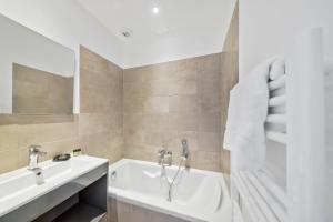 ein Badezimmer mit Badewanne und Waschbecken in der Unterkunft Résidence Pierre & Vacances Premium Les Terrasses d'Arsella in Porto-Vecchio + 74 Fotos