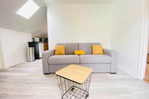 a living room with a couch with yellow pillows at Appartement Jolie vue in Laon