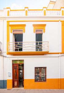 貝尼薩的住宿－Casa Casanova，一座橙色和白色的建筑,设有阳台
