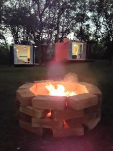 un foyer dans une cour avec une maison en arrière-plan dans l'établissement Pousada Quinta São Pedro, à Itaara