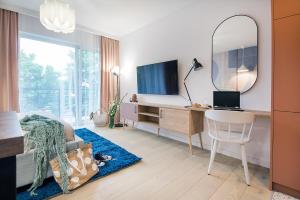 sypialnia z biurkiem, telewizorem i lustrem w obiekcie W&K Apartments - Joy Suite w Koszalinie