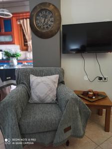 a living room with a couch and a clock on the wall at Athena's Luxury Place in Agria