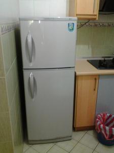 a white refrigerator with two doors in a kitchen at Homestay Serviced Apartment - Marina Court in Kota Kinabalu