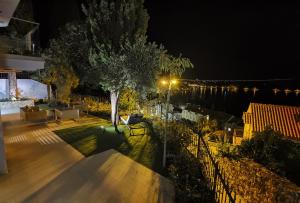 Blick auf eine Terrasse bei Nacht mit einem Baum in der Unterkunft Villa Gloria in Cavtat