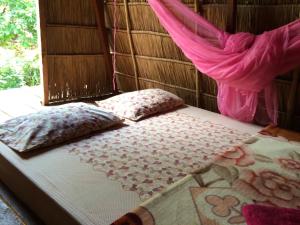 a bed in a room with pillows and a window at Tree Lodge in Sen Monorom