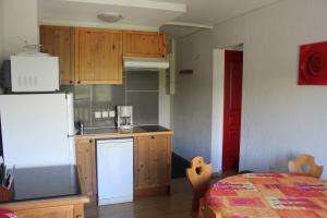 cocina con nevera blanca y encimera en Appartement Superdévoluy les 4 Géants, en Superdevoluy