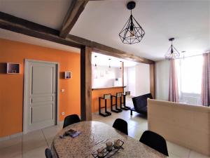 a dining room with a table and a living room at Logis de la Passerelle in Port-dʼEnvaux