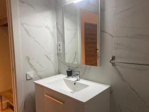 Baño blanco con lavabo y espejo en Lullaby by hamilton en Barcelona