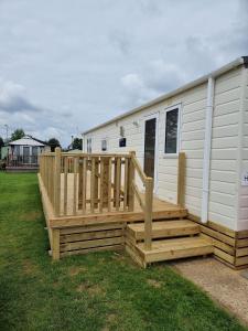 a large wooden deck next to a mobile home at Impeccable 3 bedroom lodge pet friendly in Northampton