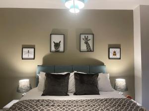 ein Schlafzimmer mit einem Bett mit vier Bildern an der Wand in der Unterkunft Central Apartment - Moderna in Blairgowrie