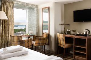 a hotel room with a bed and a desk and a window at The Angel Inn - The Inn Collection Group in Bowness-on-Windermere