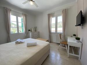 a bedroom with a bed and a desk and windows at Vasilis House in Sivota