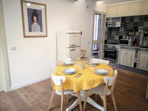 a dining room with a yellow table and chairs at Suite On Fish Market in Catania +15 photos
