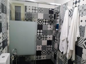 a bathroom with a shower with black and white tiles at Suite On Fish Market in Catania