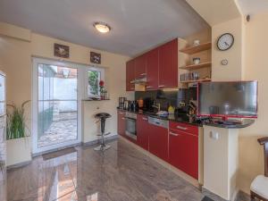 a kitchen with red cabinets and a clock on the wall at InselGlueck in Herzen Malchows in Malchow