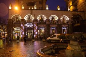 a building with a fountain in the middle of a street at night at Khreshchatyk Apart Hotel 911 in Kyiv