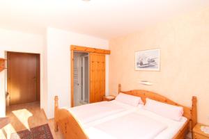 Schlafzimmer mit einem Bett mit weißer Bettwäsche in der Unterkunft Restaurant - Pension - Café Konditorei Hassler in Berg im Drautal