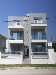 a large white building with a staircase in front of it at Mei's luxury apartments in Stavros