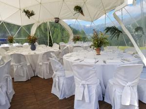 ein Raum mit weißen Tischen und Stühlen in einem Zelt in der Unterkunft Stadel Soussun in Champoluc