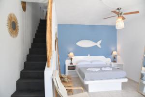 a bedroom with a bed and stairs with a blue wall at NEFELI SUITES KYTHNOS in Loutrá