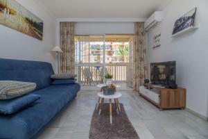 a living room with a blue couch and a tv at Erisa 68 by IVI Real Estate in Torremolinos