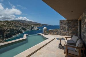a house with a swimming pool with a view of the ocean at Acro Suites - A Wellbeing Resort in Agia Pelagia