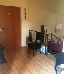 ein Wohnzimmer mit einem Stuhl und einer Treppe in der Unterkunft Altstadt Ferienwohnung in Erfurt + 25 Fotos