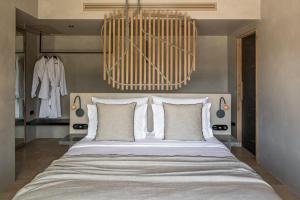 a bedroom with a large bed with white pillows at Acro Suites - A Wellbeing Resort in Agia Pelagia