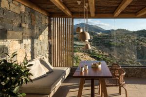 a living room with a couch and a table at Acro Suites - A Wellbeing Resort in Agia Pelagia