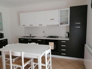 a kitchen with black and white cabinets and a white table at Casa Teresa in Ledro