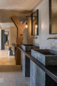 a bathroom with two sinks and a wooden arrow on the wall at Acro Suites - A Wellbeing Resort in Agia Pelagia