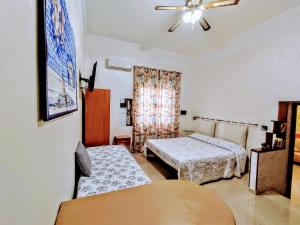 a bedroom with two beds and a ceiling fan at Bed & Breakfast Delle Palme in Trapani