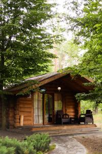 Cabaña de madera con sillas y porche en Resort Stariy Prud, en Filippovichi