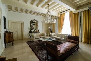a living room with couches and a table and a chandelier at Villa San Pietro in Desenzano del Garda