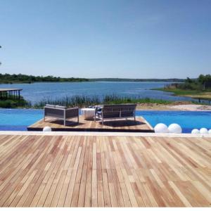 a pool with two benches and a view of the water at Lira Boutique Lodge in Thohoyandou