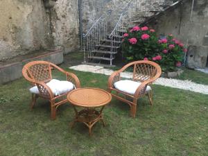 3 chaises, une table, une table et un escalier dans l'établissement un dimanche chez Julie chambre Léontine, à Parthenay