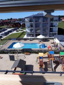 a view of a pool with a playground and a hotel at Apartament BLU37 in Sarbinowo