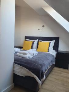 a bedroom with a blue bed with yellow pillows at Apartament BLU37 in Sarbinowo