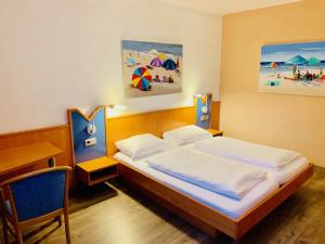 une chambre avec un lit et un bureau et un lit sidx sidx sidx dans l'établissement Hotel Europa - Restaurant, à Rüsselsheim