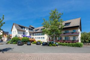 um grande edifício com carros estacionados num parque de estacionamento em Hotel Eydt Kirchheim em Kirchheim