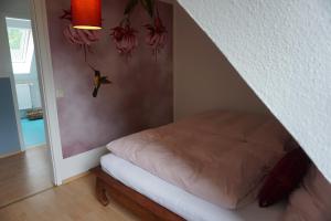 Bett in einem Zimmer mit einer Wand mit Blumen in der Unterkunft Mirabella in Lüneburg