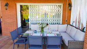 una mesa con un sofá blanco y sillas en el patio en Stay U-nique Villa Portimar, en Arenys de Mar