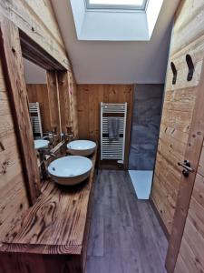 a bathroom with two sinks and a skylight at Gite de la Bourbatte in Gerbamont 